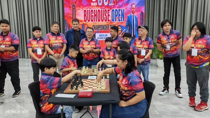 The ceremonial game at the board in front of the championship backdrop
