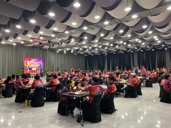 The playing hall of the MICE Center with the teams at the boards