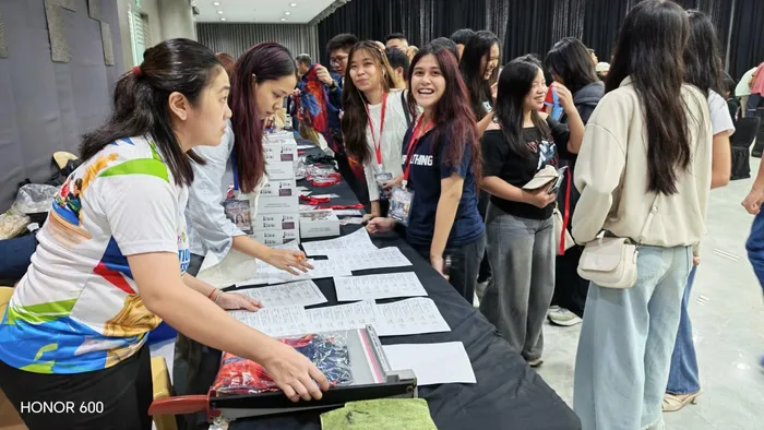 Participants collecting their tournament IDs and event shirts at the registration desk
