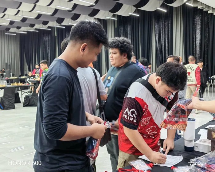 Players signing for their official event shirts before the start