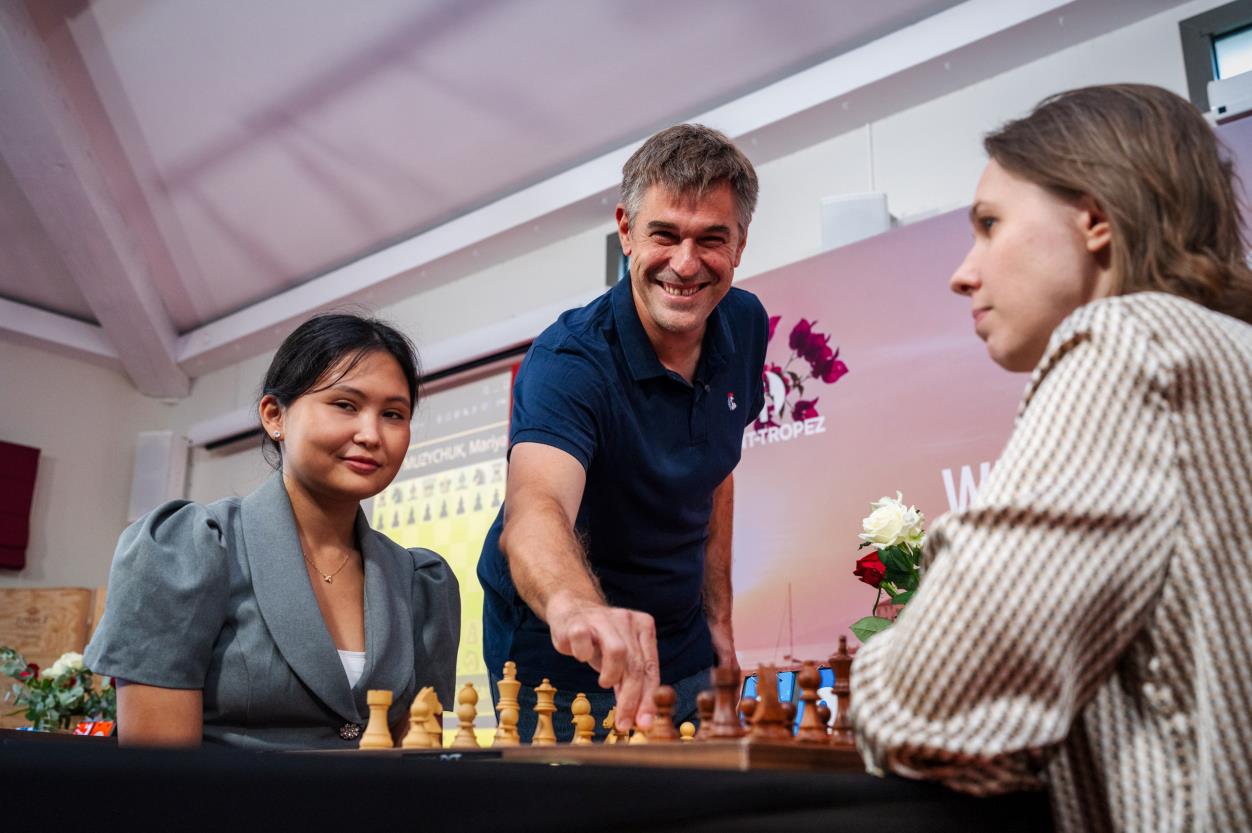 Eloi Relange making the ceremonial first move between Assaubayeva and Mariya Muzychuk