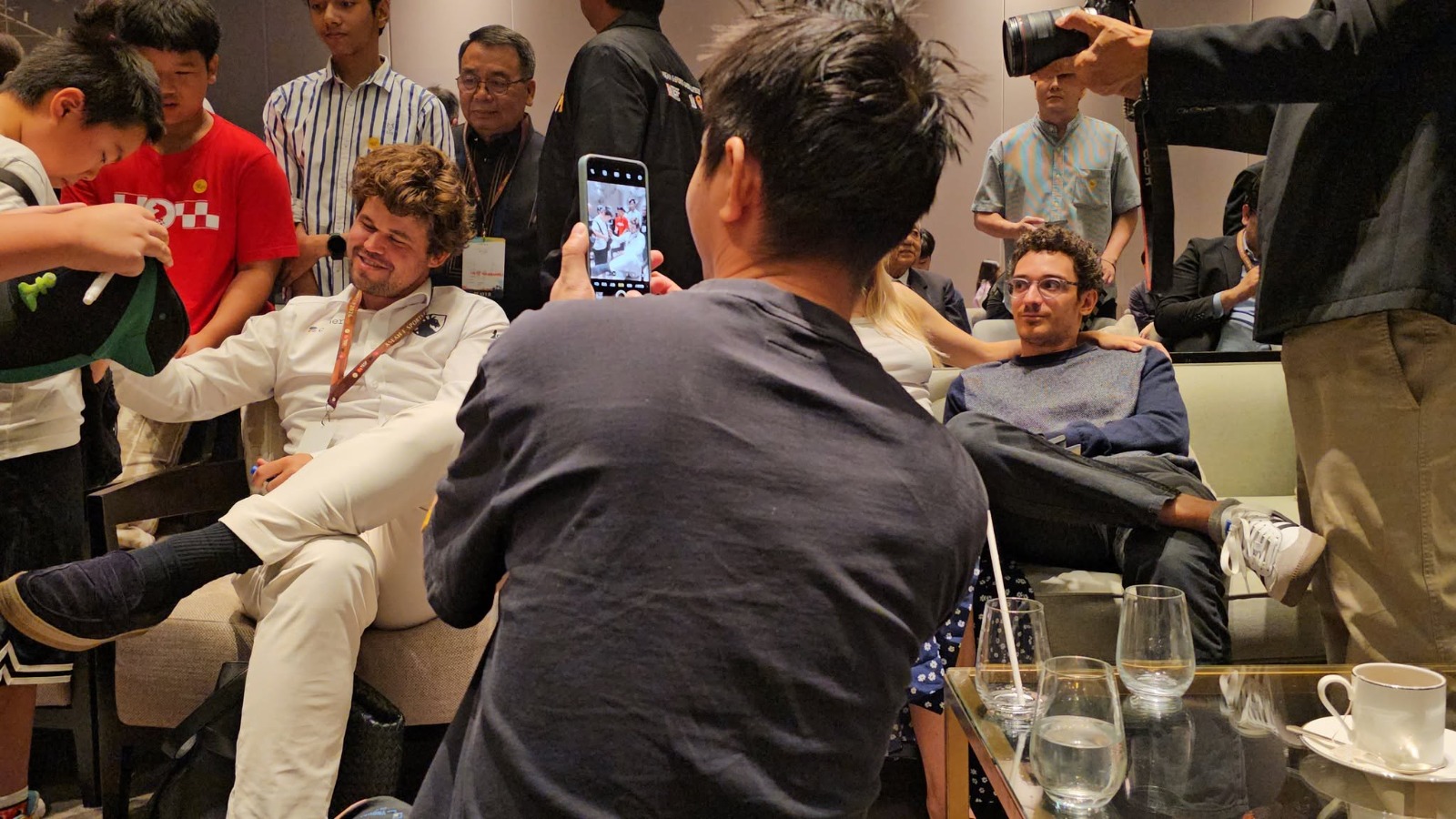 Magnus Carlsen and Fabiano Caruana surrounded by fans